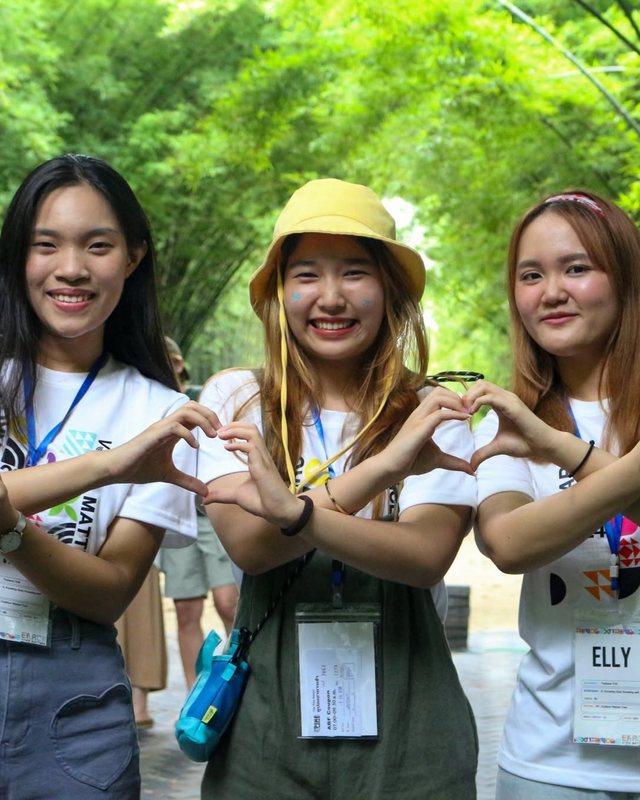 Three students making heart hand-signs on a past EARC outing
